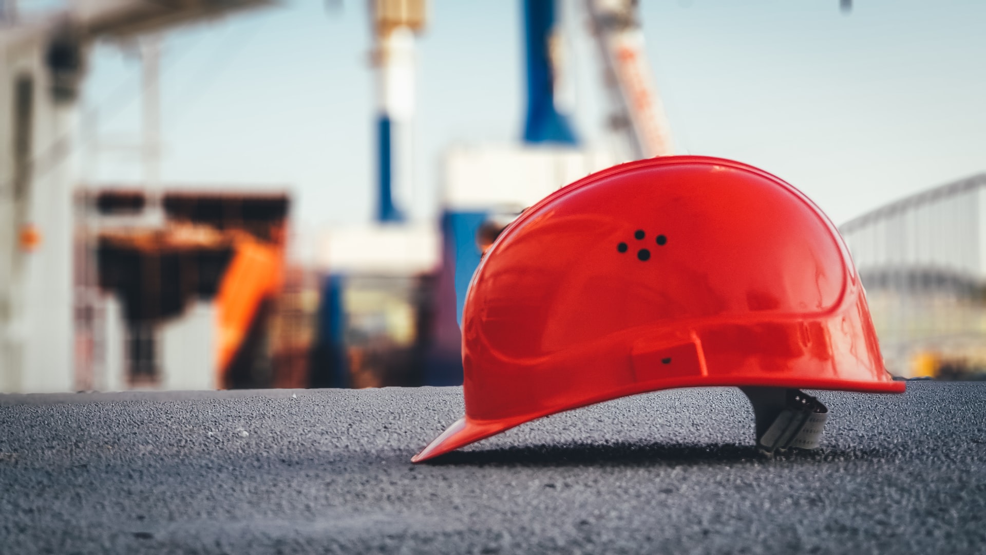 Capacete EPI trabalhador vermelho no chão